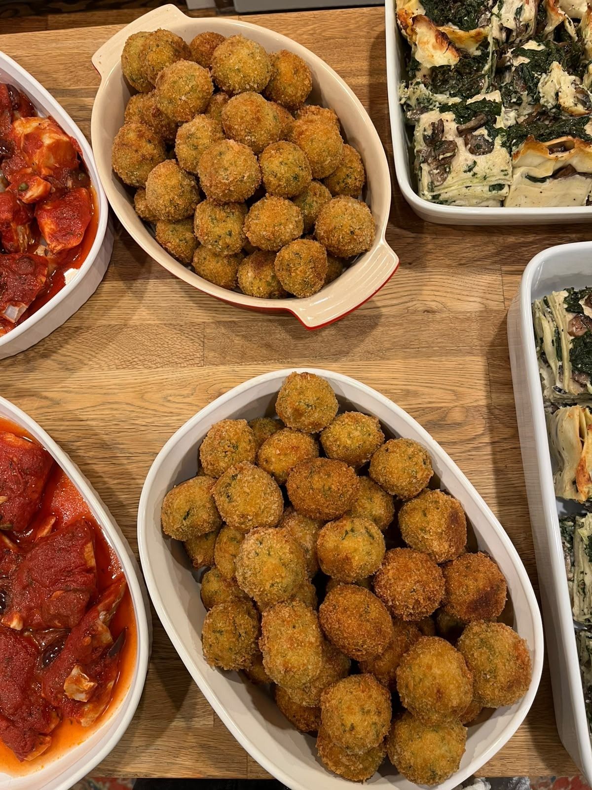 Two dishes of golden fried fish croquettes flecked with herbs